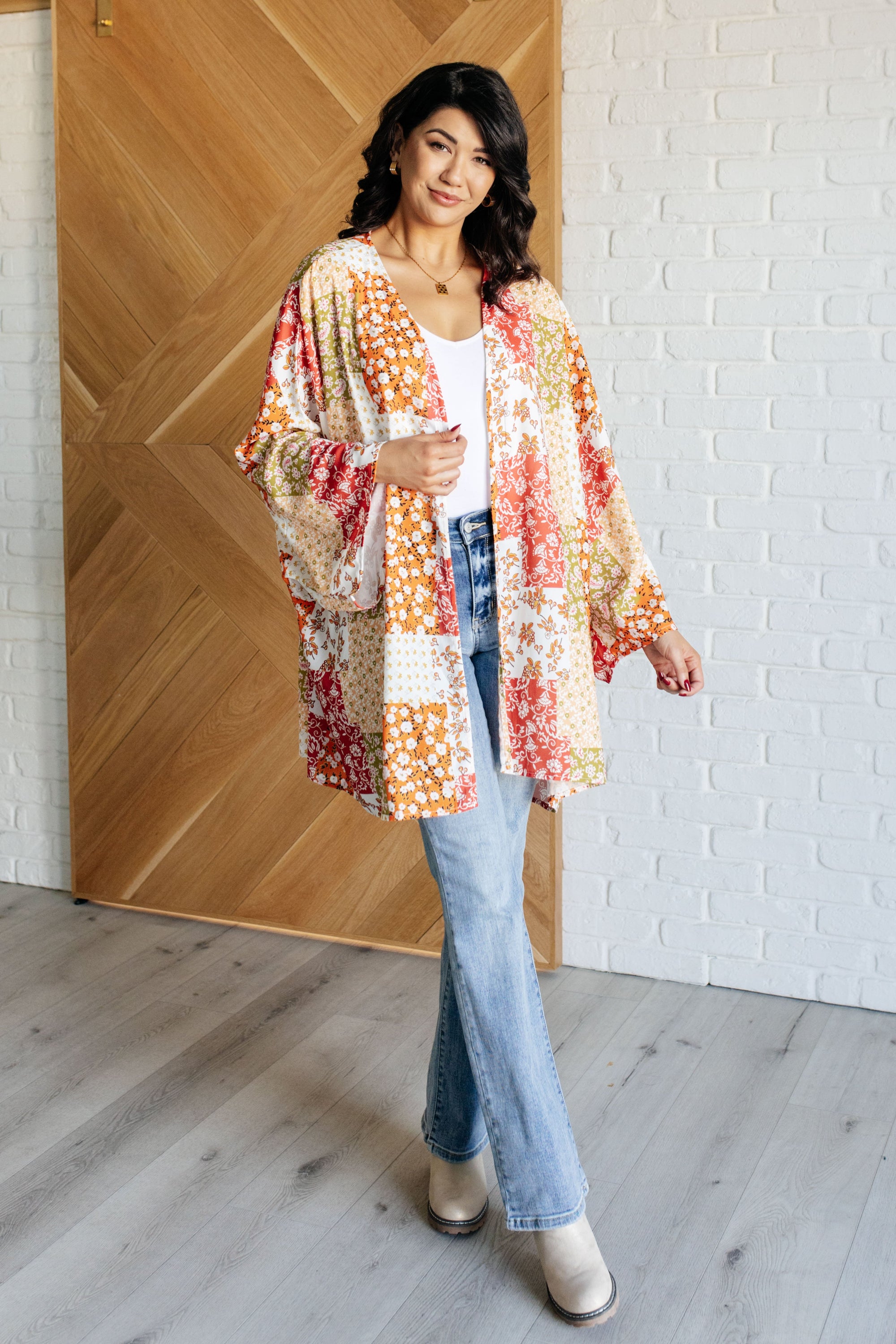 A vibrant mixed floral kimono with dolman sleeves and an open front, made from lightweight poplin fabric.