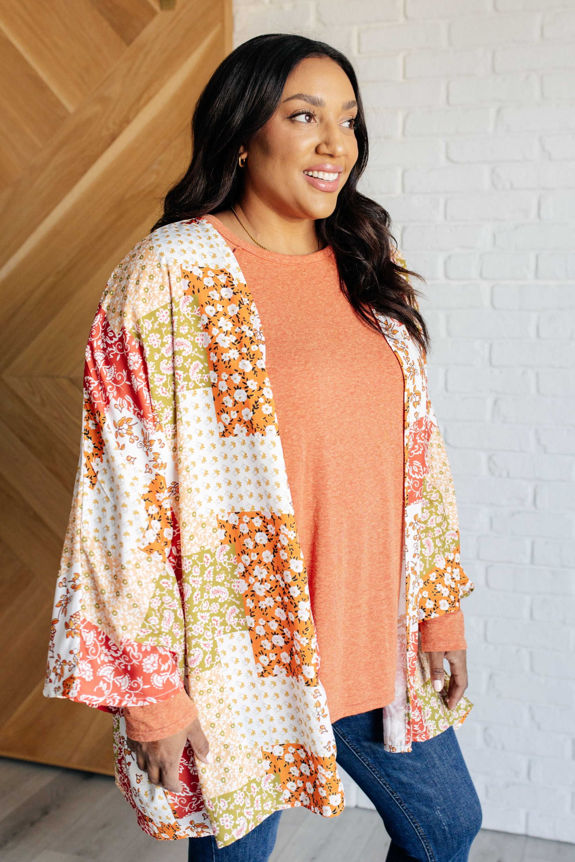 A vibrant mixed floral kimono with dolman sleeves and an open front, made from lightweight poplin fabric.