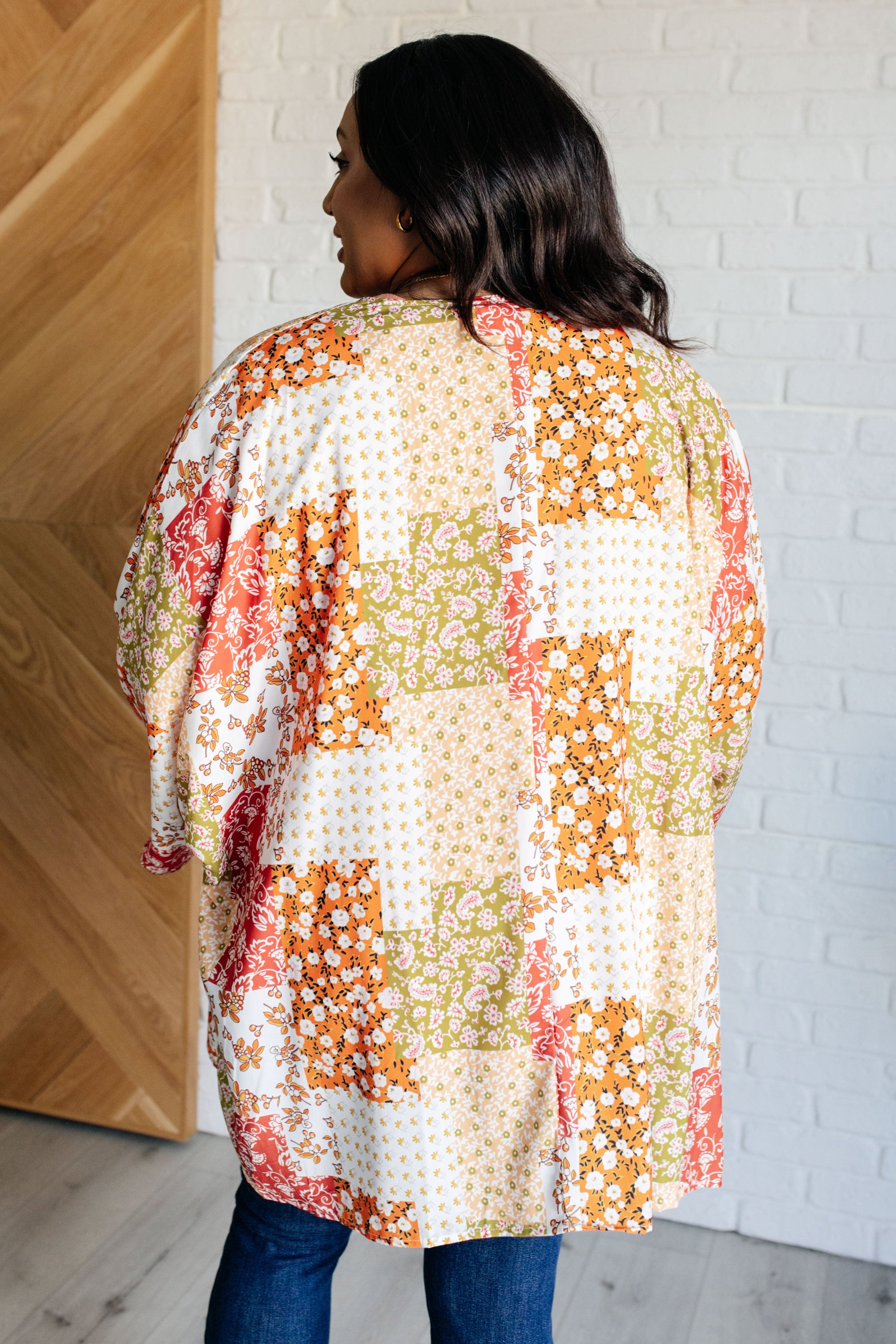 A vibrant mixed floral kimono with dolman sleeves and an open front, made from lightweight poplin fabric.