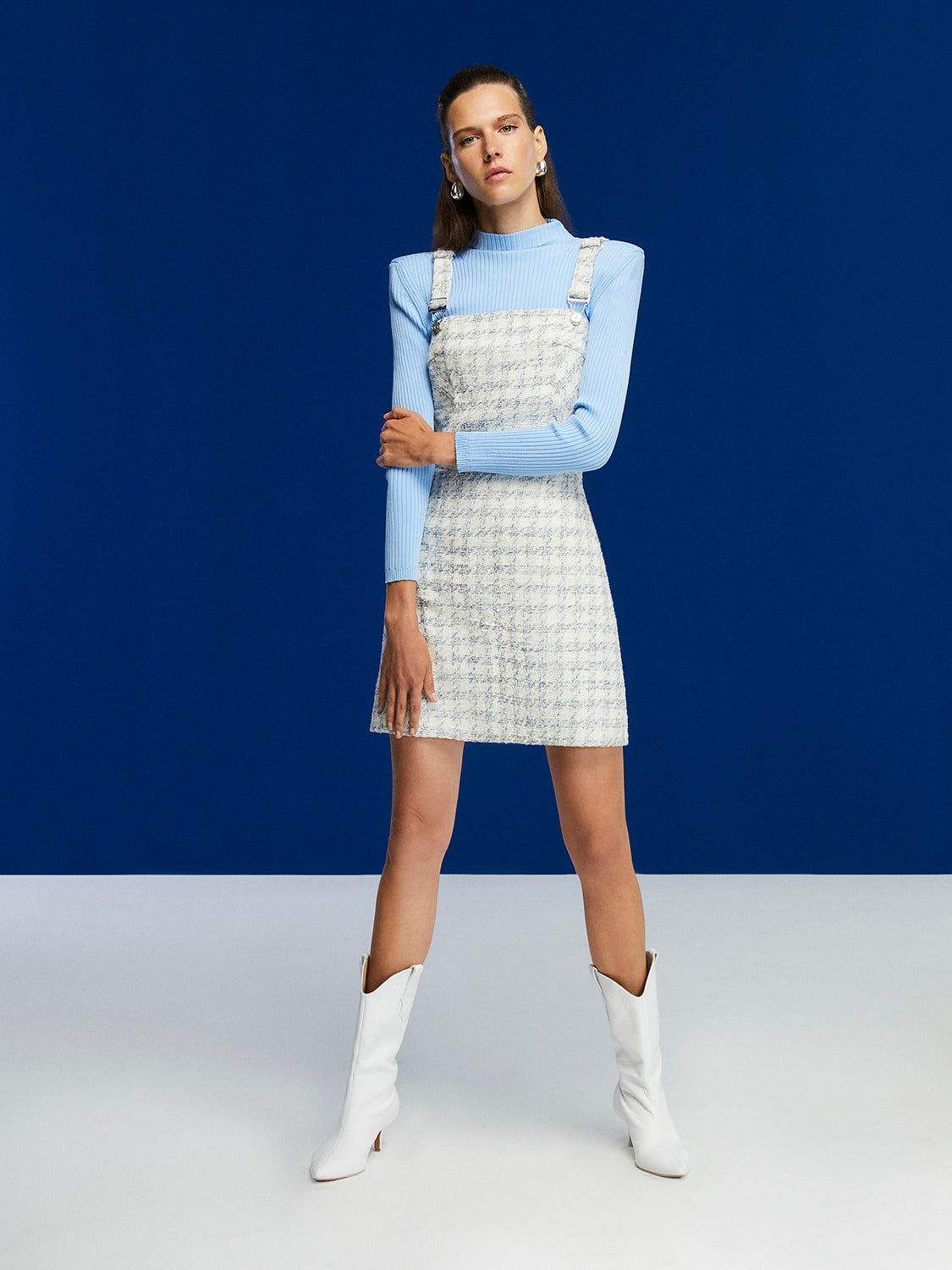 A stylish plaid overall dress featuring adjustable straps and a zip closure at the back, perfect for casual outings.