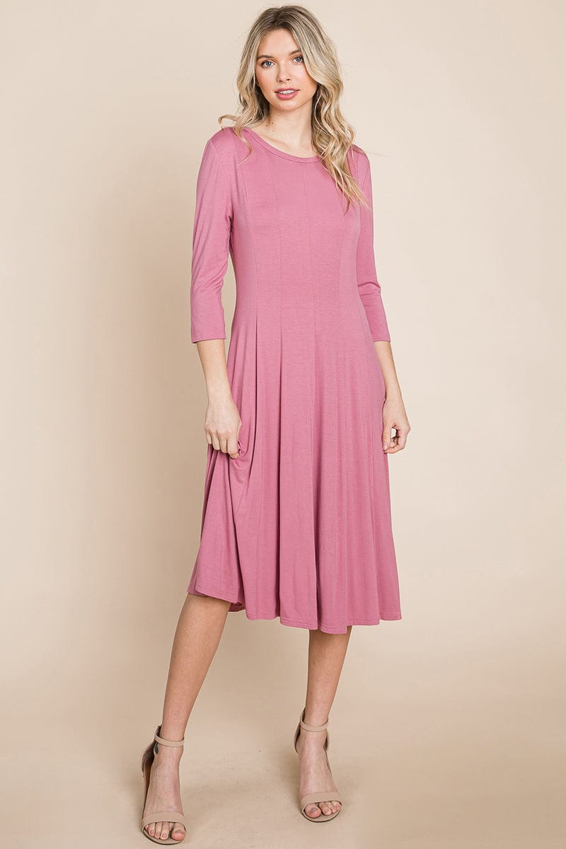 A model wearing a Pleated 3/4 Sleeve A-line Flare Midi Jersey Dress in a solid color, showcasing its elegant boat neck and flattering silhouette.