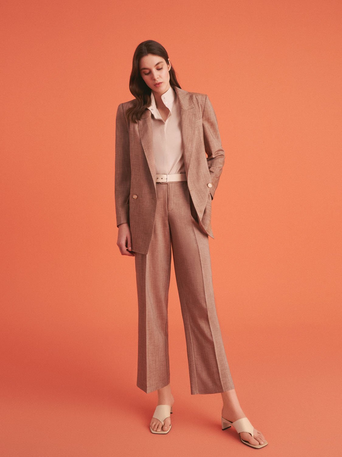 A pair of stylish ankle-length pleated high-waisted pants with a metal buckle belt, showcasing a chic design suitable for summer wear.