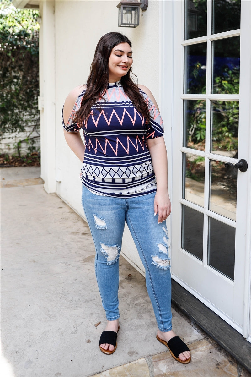 A stylish plus size cold shoulder top featuring a navy polka dot print, short cuffed sleeves, and a back self-tie detail, perfect for casual outings.