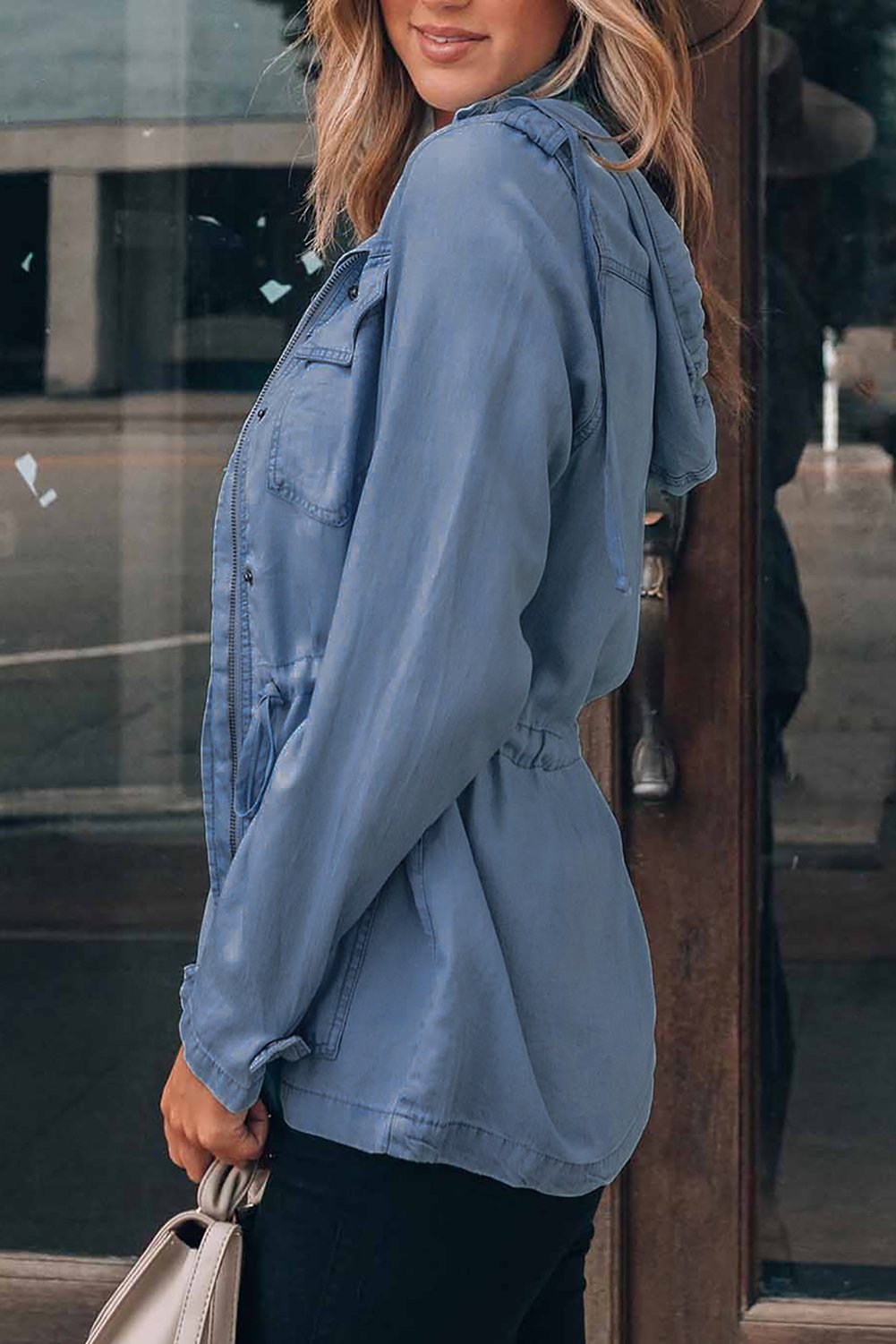 A stylish hooded jacket featuring a front zipper, button closure, and drawstring waistline, perfect for chilly weather.