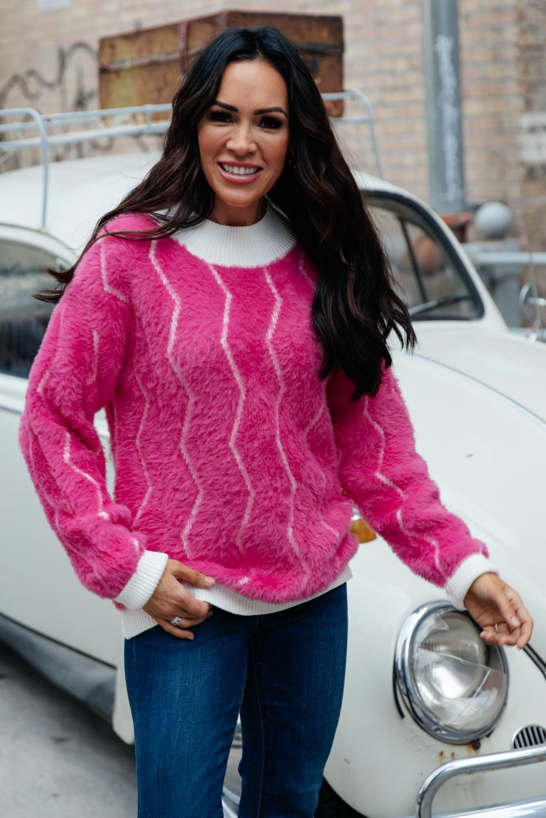 Bright pink Pop Culture Zig Zag Sweater with white collar and cuffs, displayed on a mannequin.