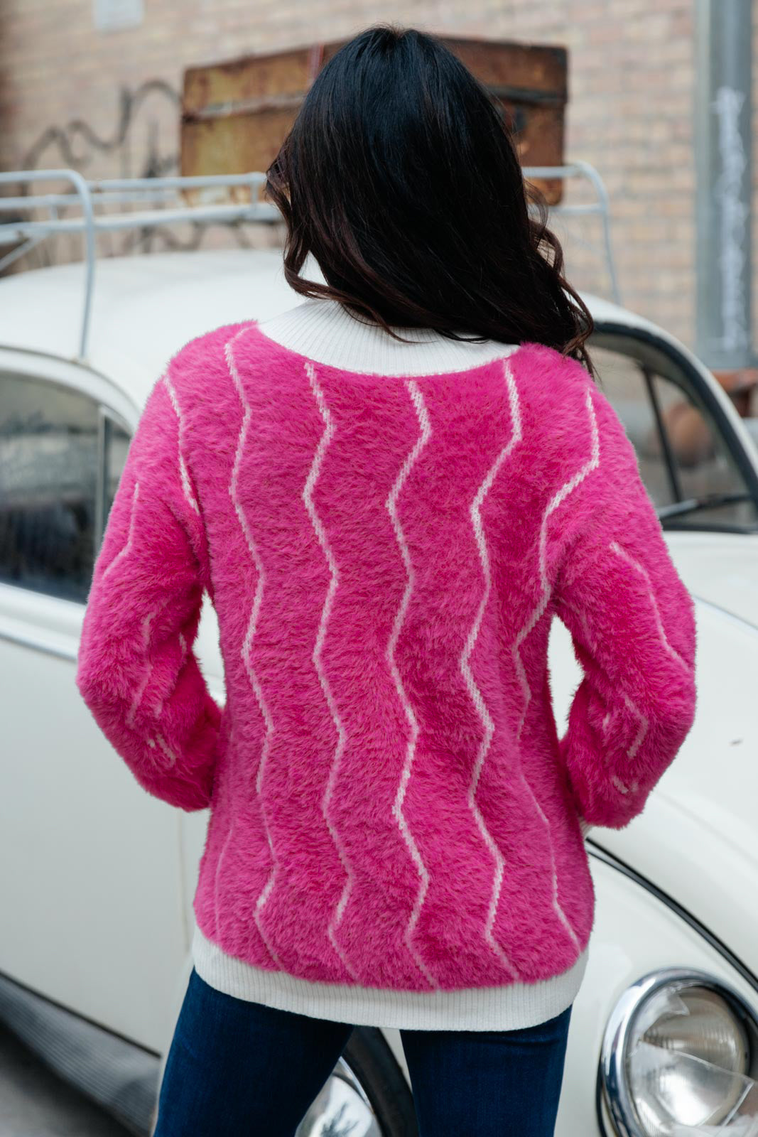 Bright pink Pop Culture Zig Zag Sweater with white collar and cuffs, displayed on a mannequin.