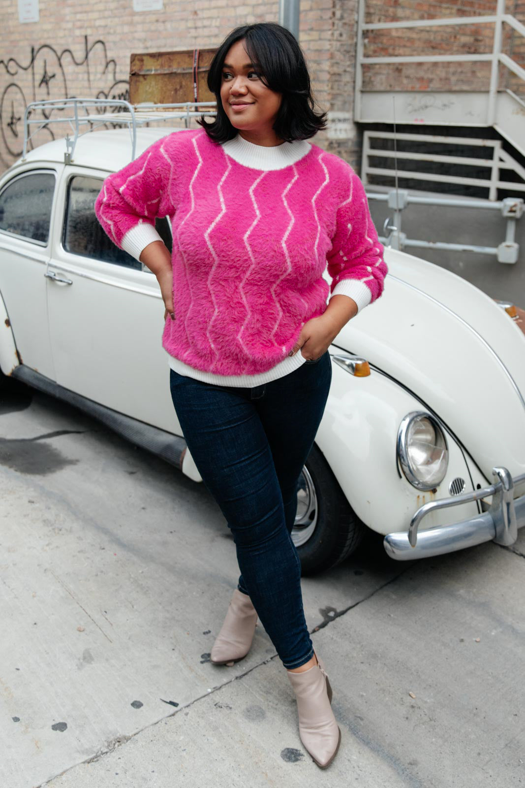 Bright pink Pop Culture Zig Zag Sweater with white collar and cuffs, displayed on a mannequin.
