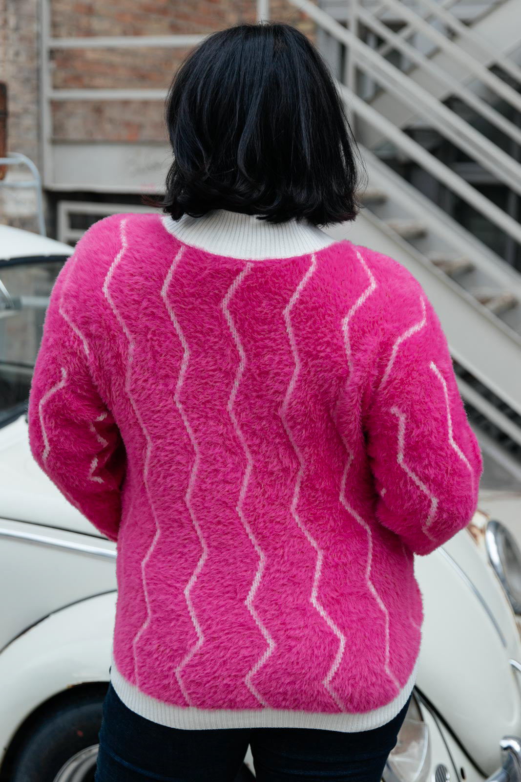 Bright pink Pop Culture Zig Zag Sweater with white collar and cuffs, displayed on a mannequin.