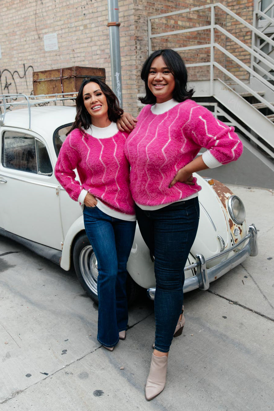 Bright pink Pop Culture Zig Zag Sweater with white collar and cuffs, displayed on a mannequin.