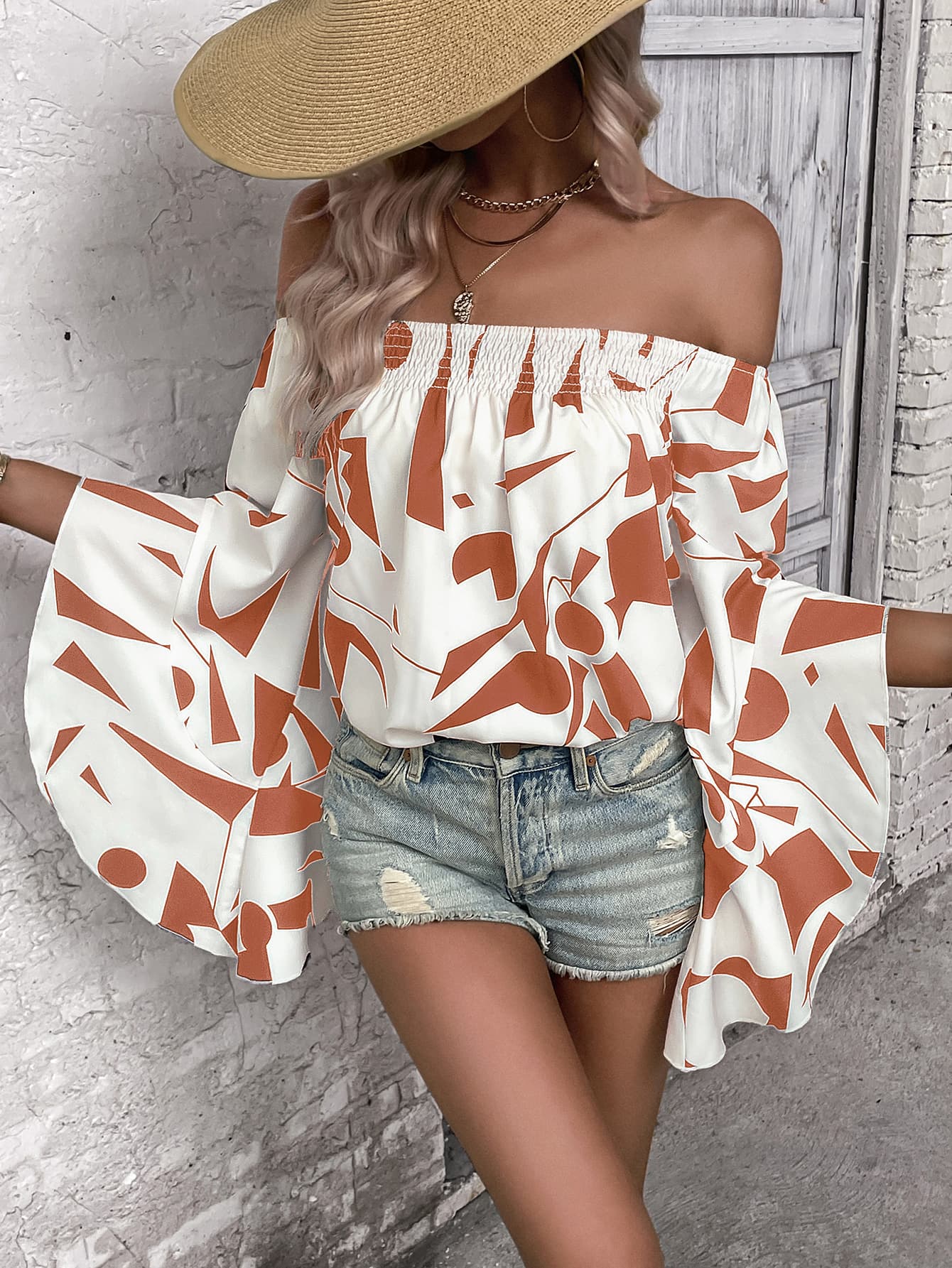 A stylish Printed Off-Shoulder Bell Sleeve Blouse featuring a chic geometric pattern, smocked design, and elegant bell sleeves.