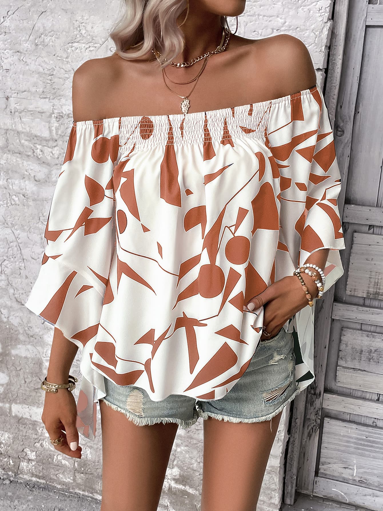 A stylish Printed Off-Shoulder Bell Sleeve Blouse featuring a chic geometric pattern, smocked design, and elegant bell sleeves.