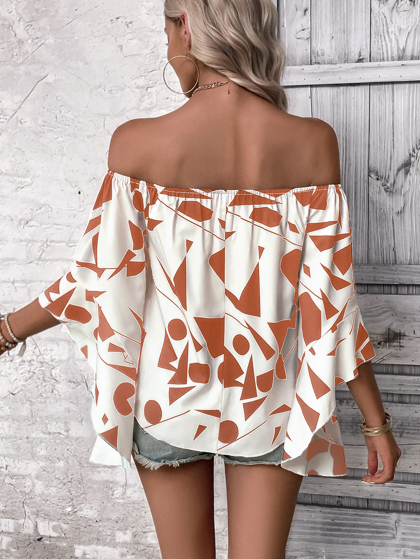 A stylish Printed Off-Shoulder Bell Sleeve Blouse featuring a chic geometric pattern, smocked design, and elegant bell sleeves.