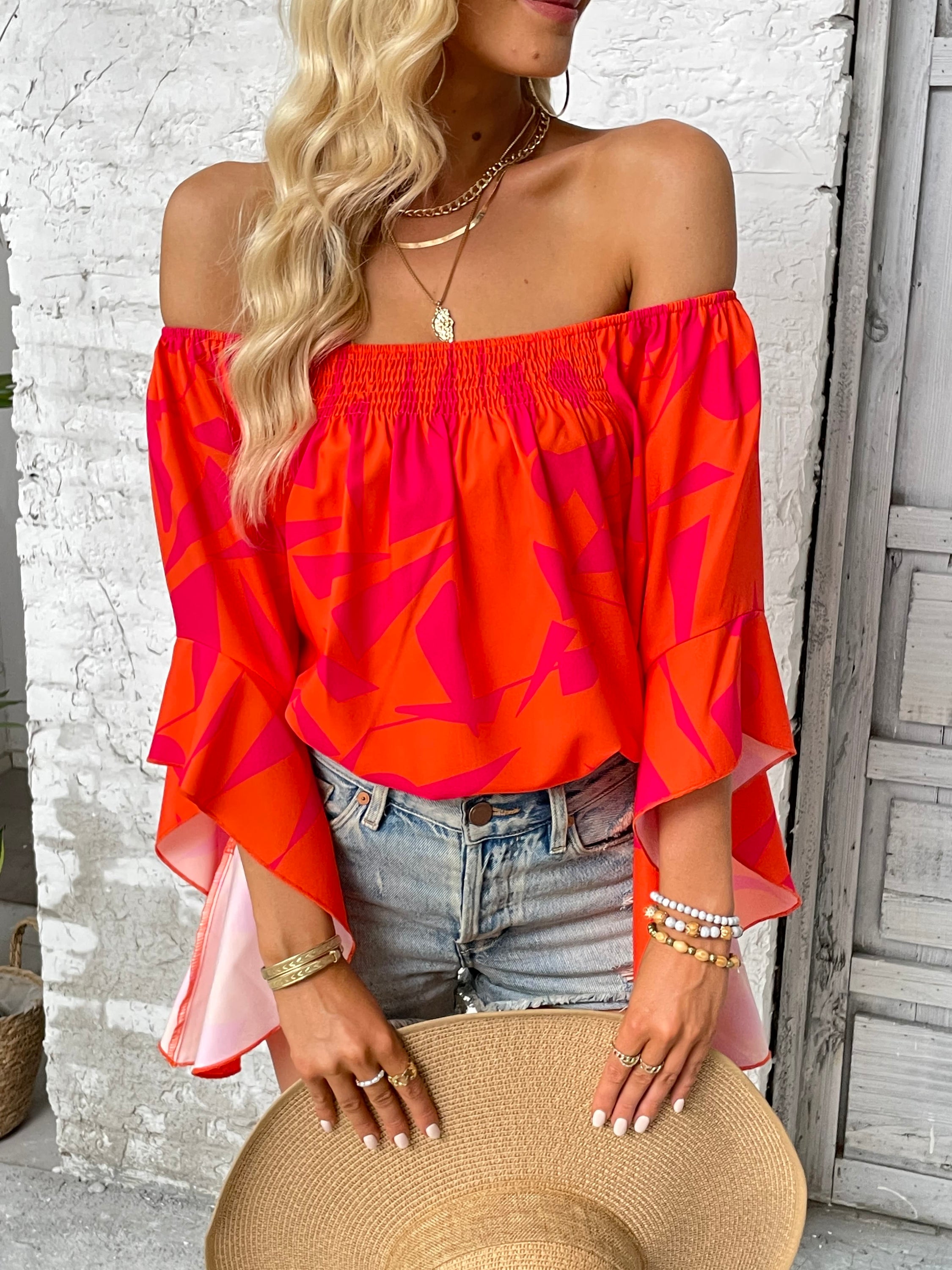 A stylish Printed Off-Shoulder Bell Sleeve Blouse featuring a chic geometric pattern, smocked design, and elegant bell sleeves.