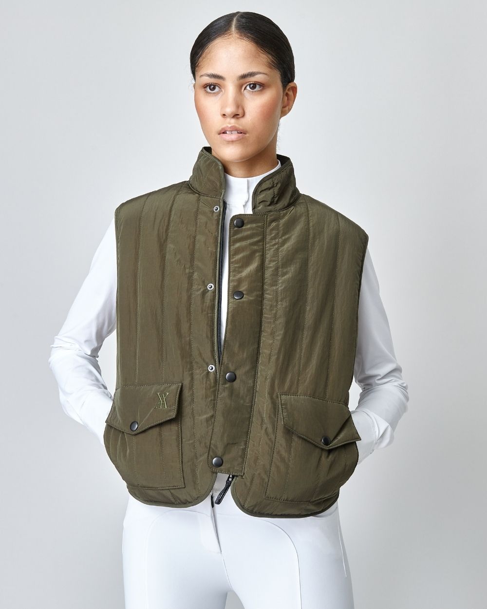 Green Quilted Riding Vest with stand-up collar and front zipper, featuring multiple pockets and embroidered logo.