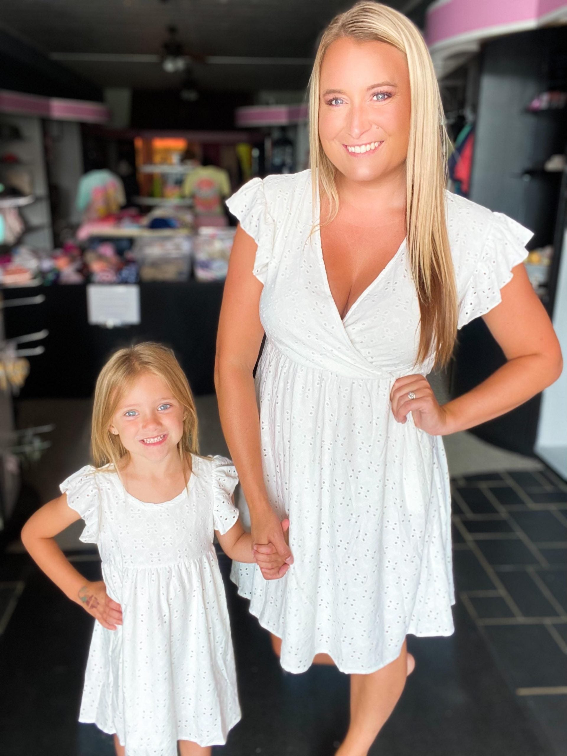 Rebecca Ruffle Eyelet Dress displayed in seven colors, showcasing its soft fabric, elastic waistband, and flattering design.