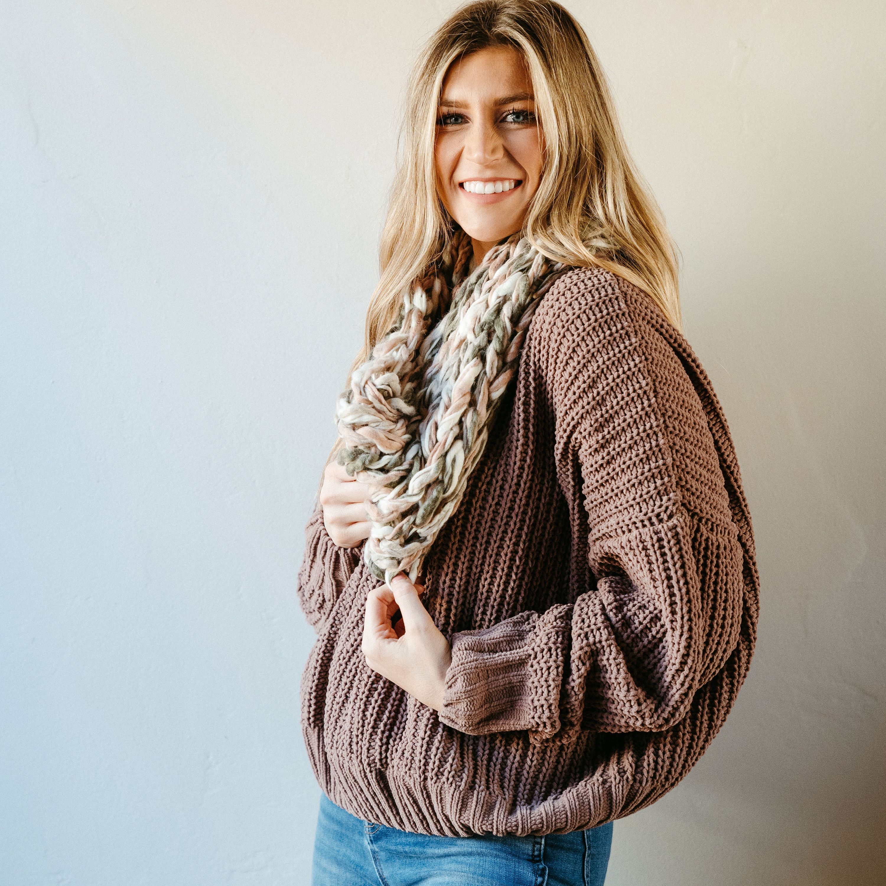 A cozy rose thick knit infinity scarf, elegantly draped, showcasing its soft texture and warm design, perfect for winter wear.