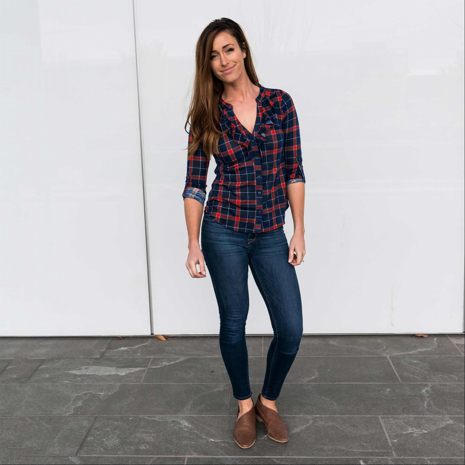 A stylish Ruffle Front Plaid Top featuring a feminine ruffle design, button-down front, and three-quarter length sleeves, perfect for a chic cowgirl look.