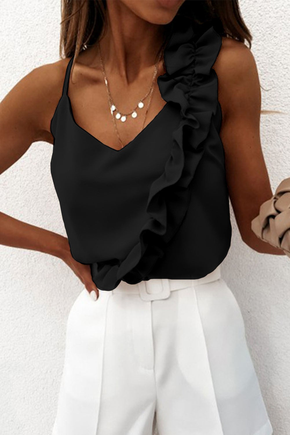 Elegant black ruffle top with spaghetti straps and decorative ruffles, showcasing a deep neckline.