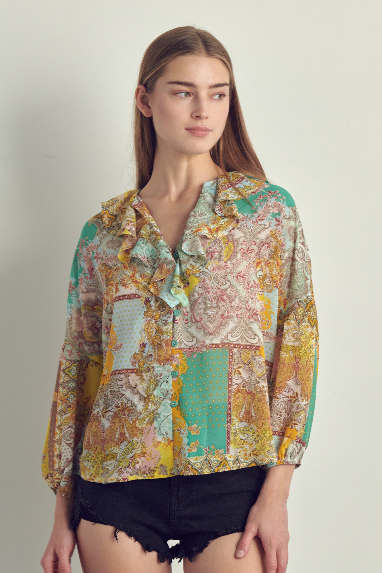 A stylish Ruffle Neck Button Long Sleeve blouse in chiffon featuring a vibrant paisley print in blue/pink and orange/green, displayed on a model.