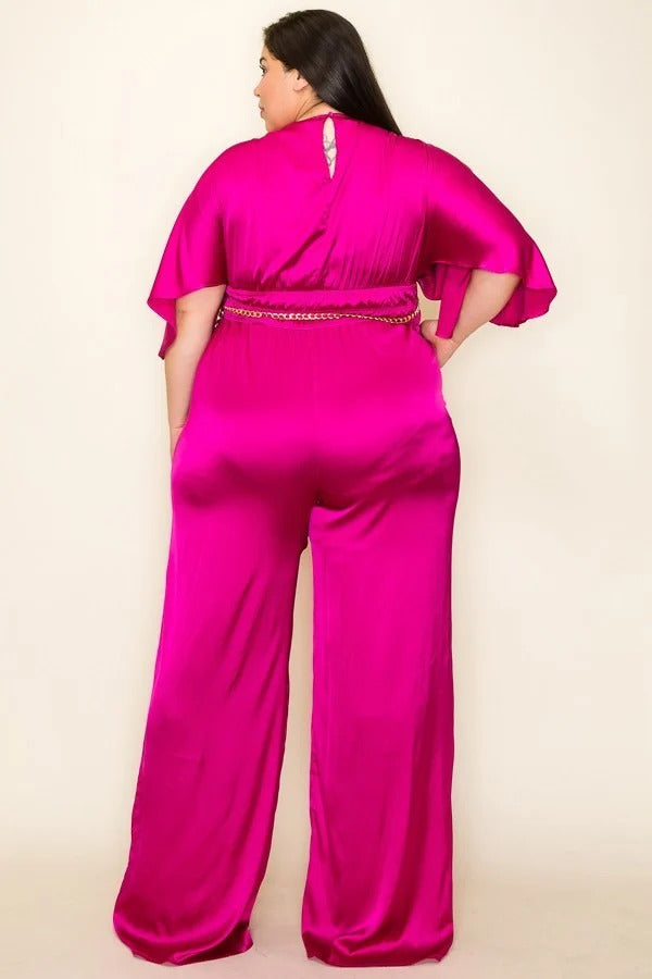 A stylish magenta satin jumpsuit featuring a wrap front, short sleeves, and a smocked waist with a chain belt.