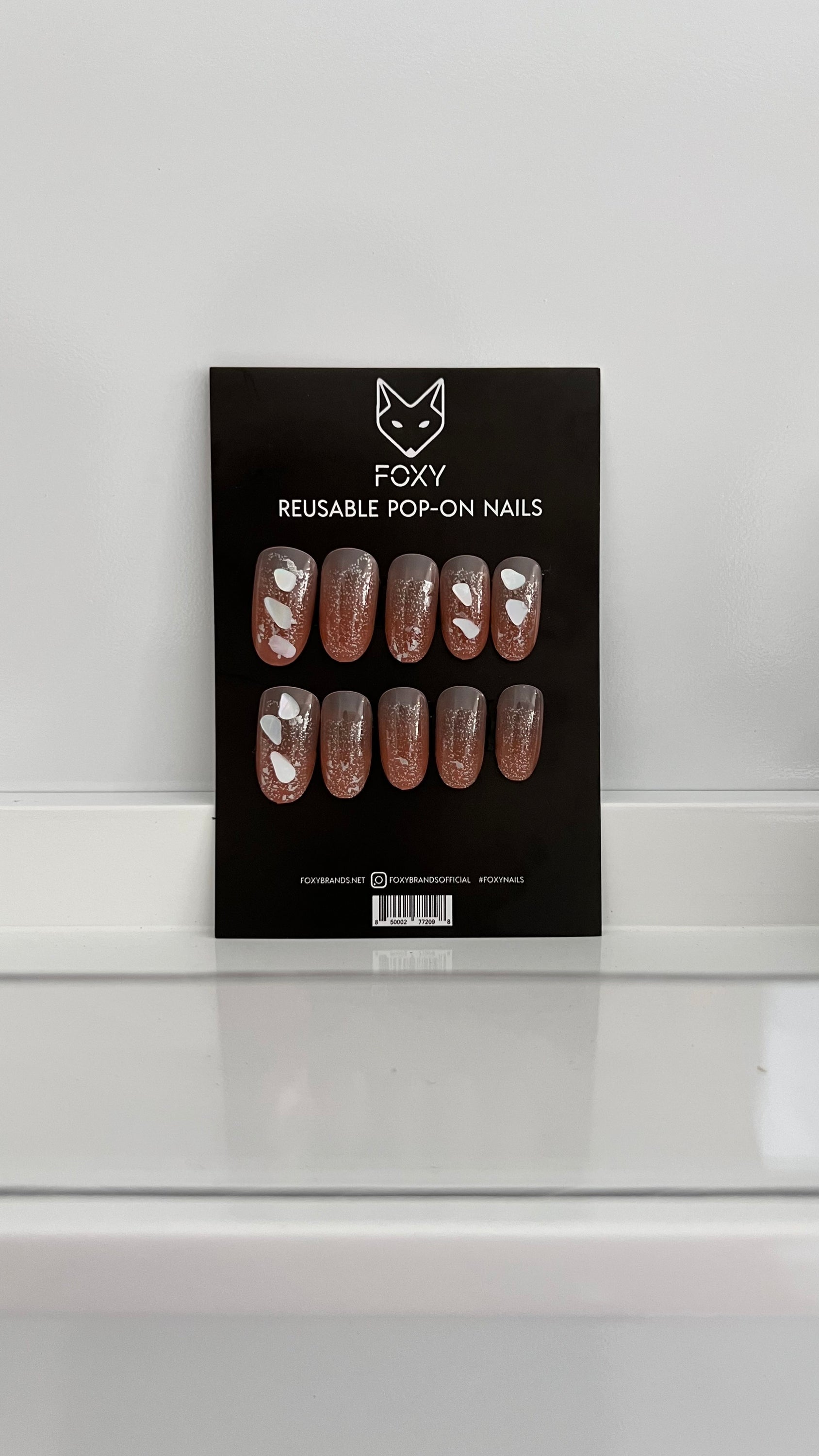 A set of SeaShell-Stiletto pop-on nails in various sizes, showcasing a stylish and elegant design perfect for a quick manicure.