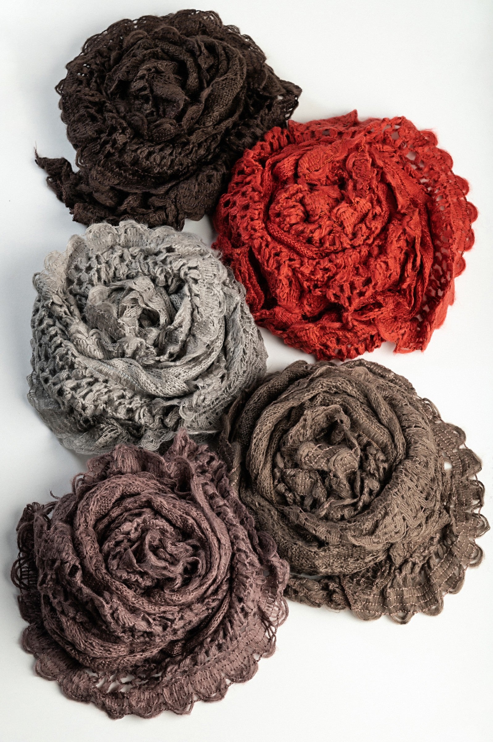 A colorful set of five knitted scarves in dark brown, brick, olive, purple, and light gray, showcasing their soft texture and vibrant hues.