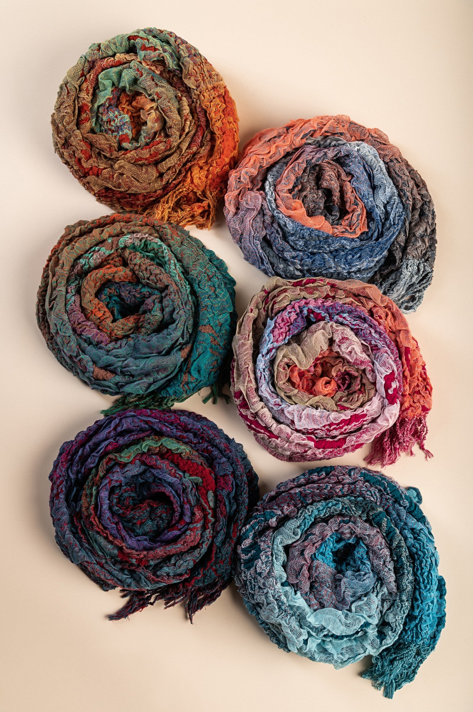 A vibrant set of 6 multicolored scarves made from 100% viscose, showcasing colors like brown, orange, grey, turquoise, violet, and red.