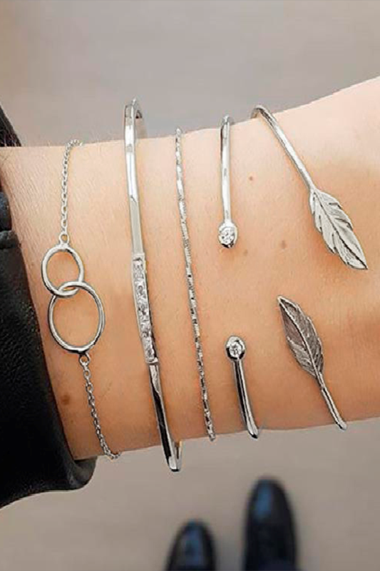 Set of five elegant silver bracelets with unique pendants displayed together.