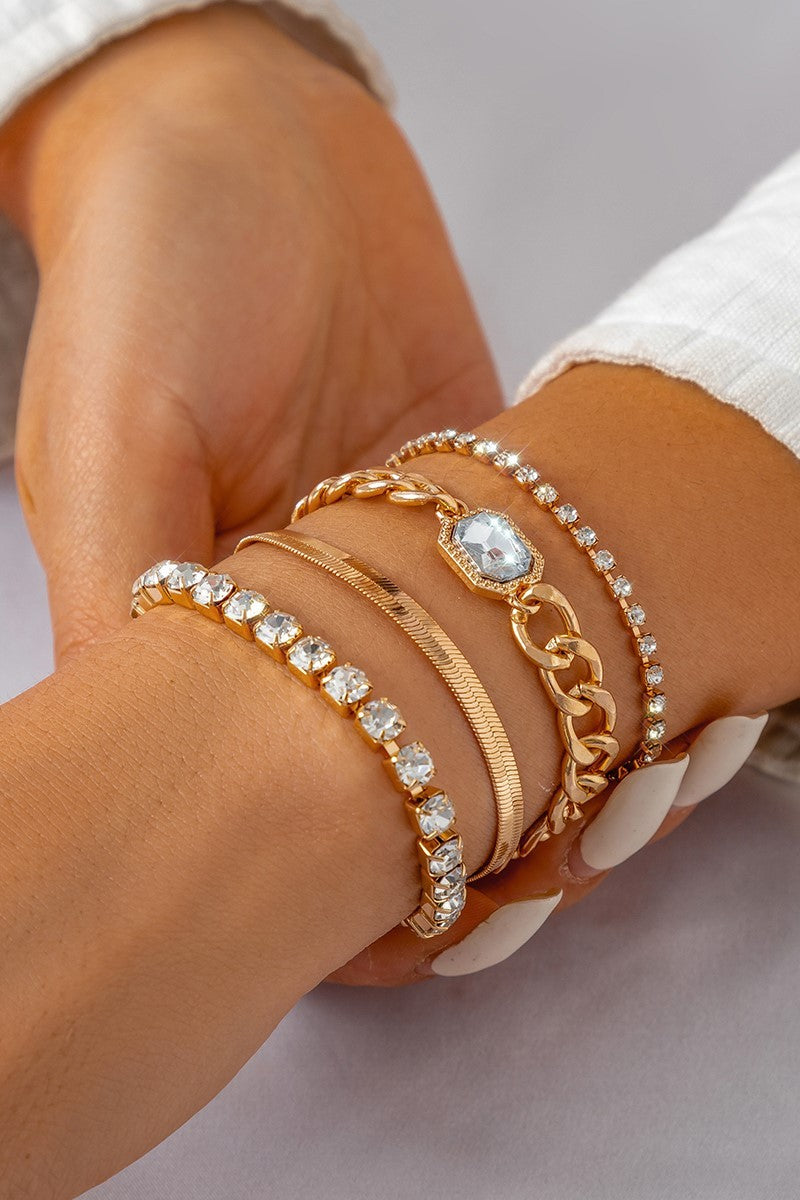 A set of four elegant gold bracelets adorned with rhinestones, featuring a secure metal carabiner closure.