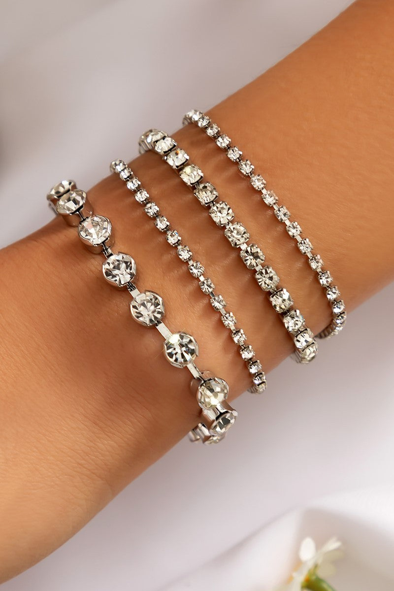 A stylish set of four white rhinestone bracelets featuring decorative stones and a metal lobster clasp closure.
