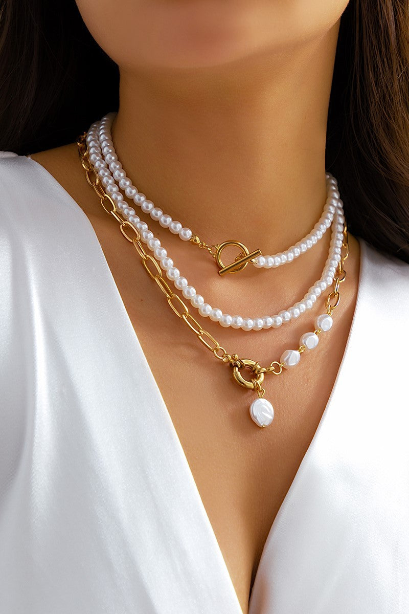 Set of three elegant gold necklaces with imitation pearls, showcasing a stylish design and metal lobster clasp.