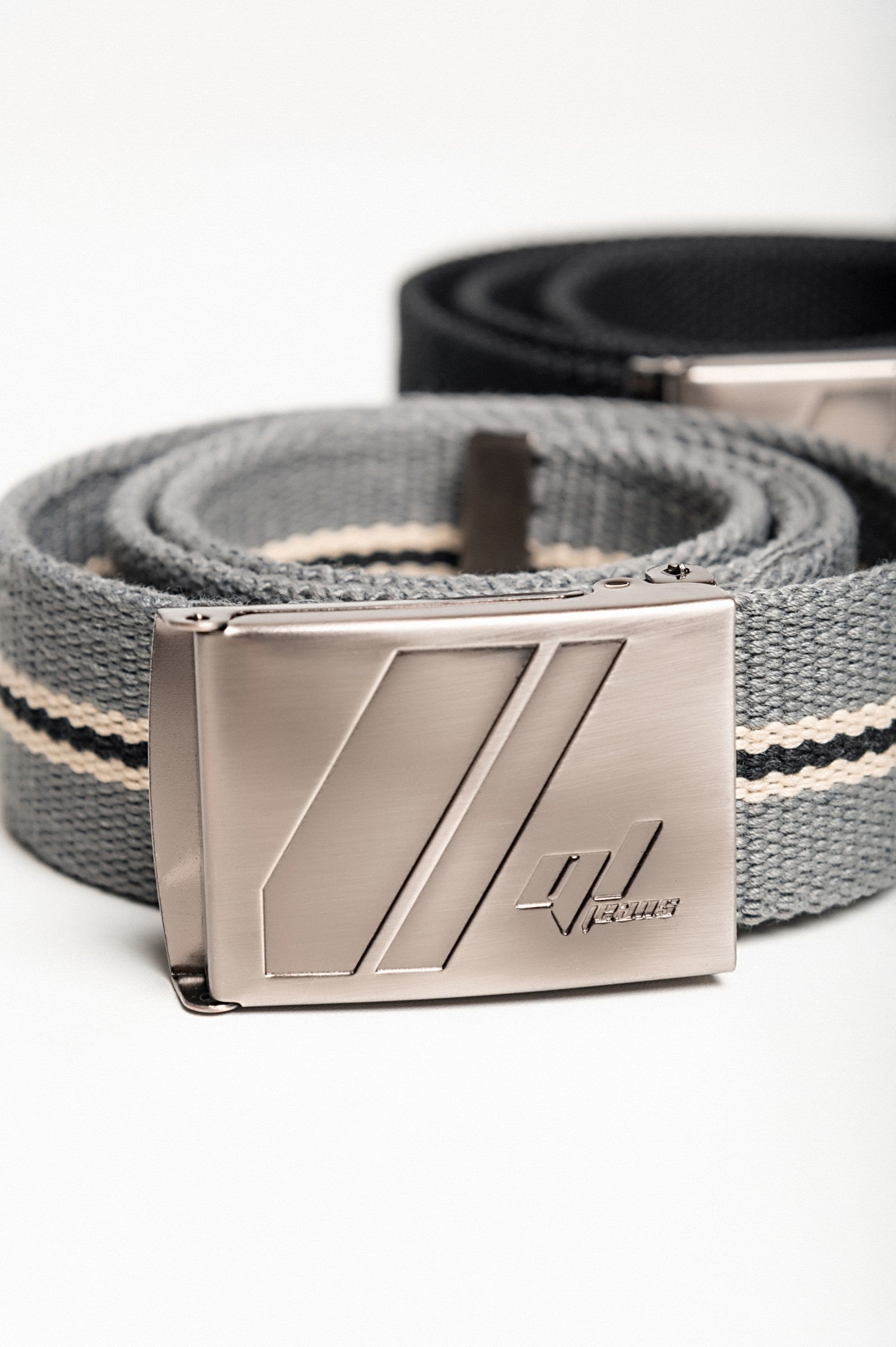 Set of two adjustable belts in black and gray with engraved metal buckles.