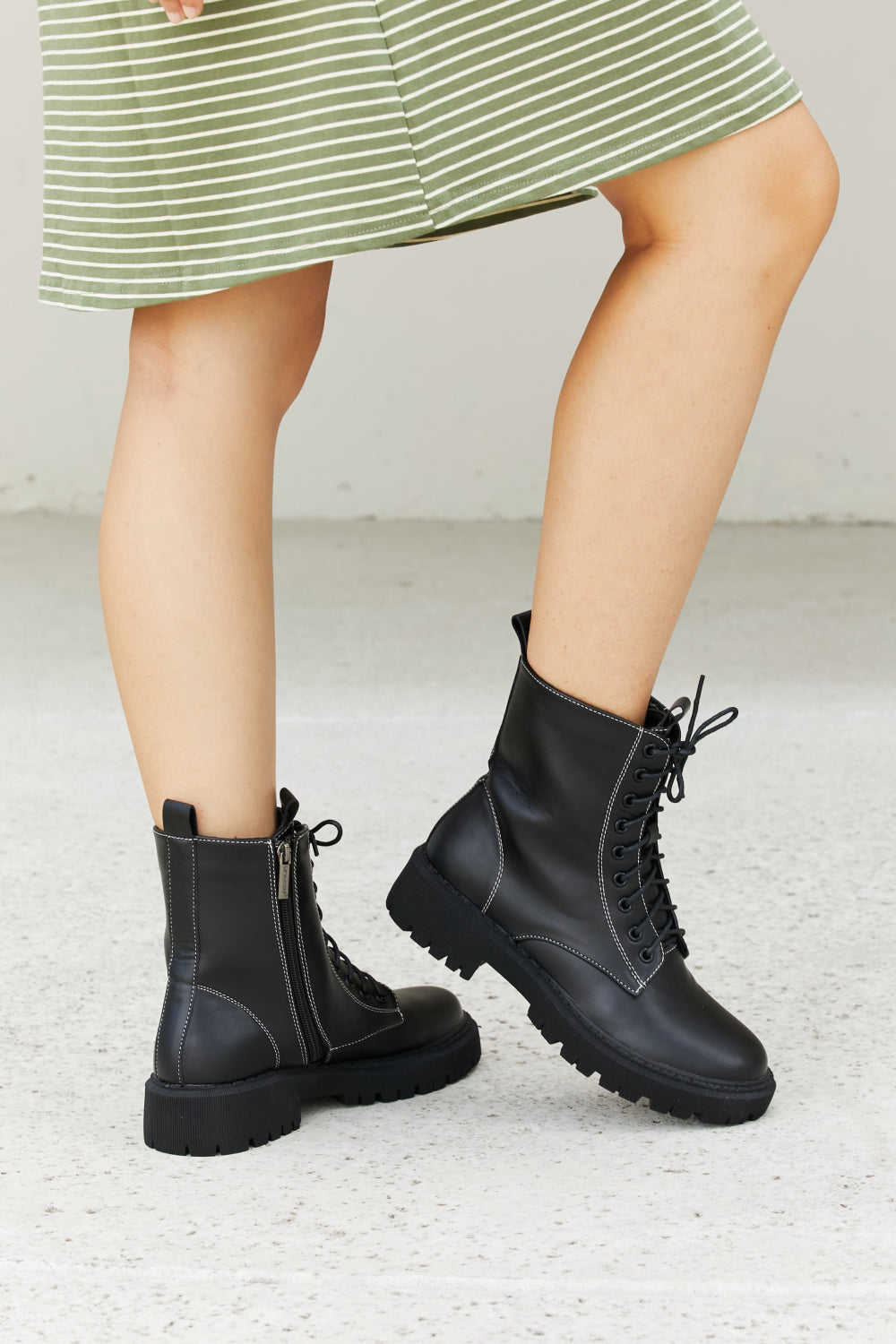 Set the Mood Lug Sole Combat Booties featuring a round toe, low platform heel, and stylish faux leather design.