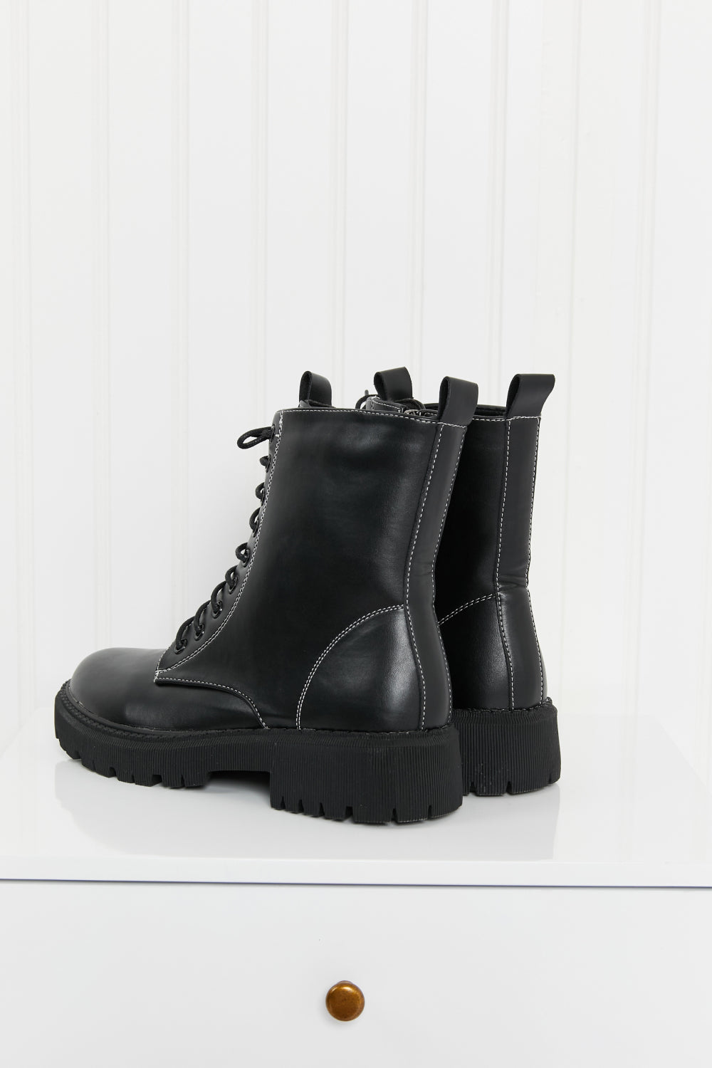 Set the Mood Lug Sole Combat Booties featuring a round toe, low platform heel, and stylish faux leather design.