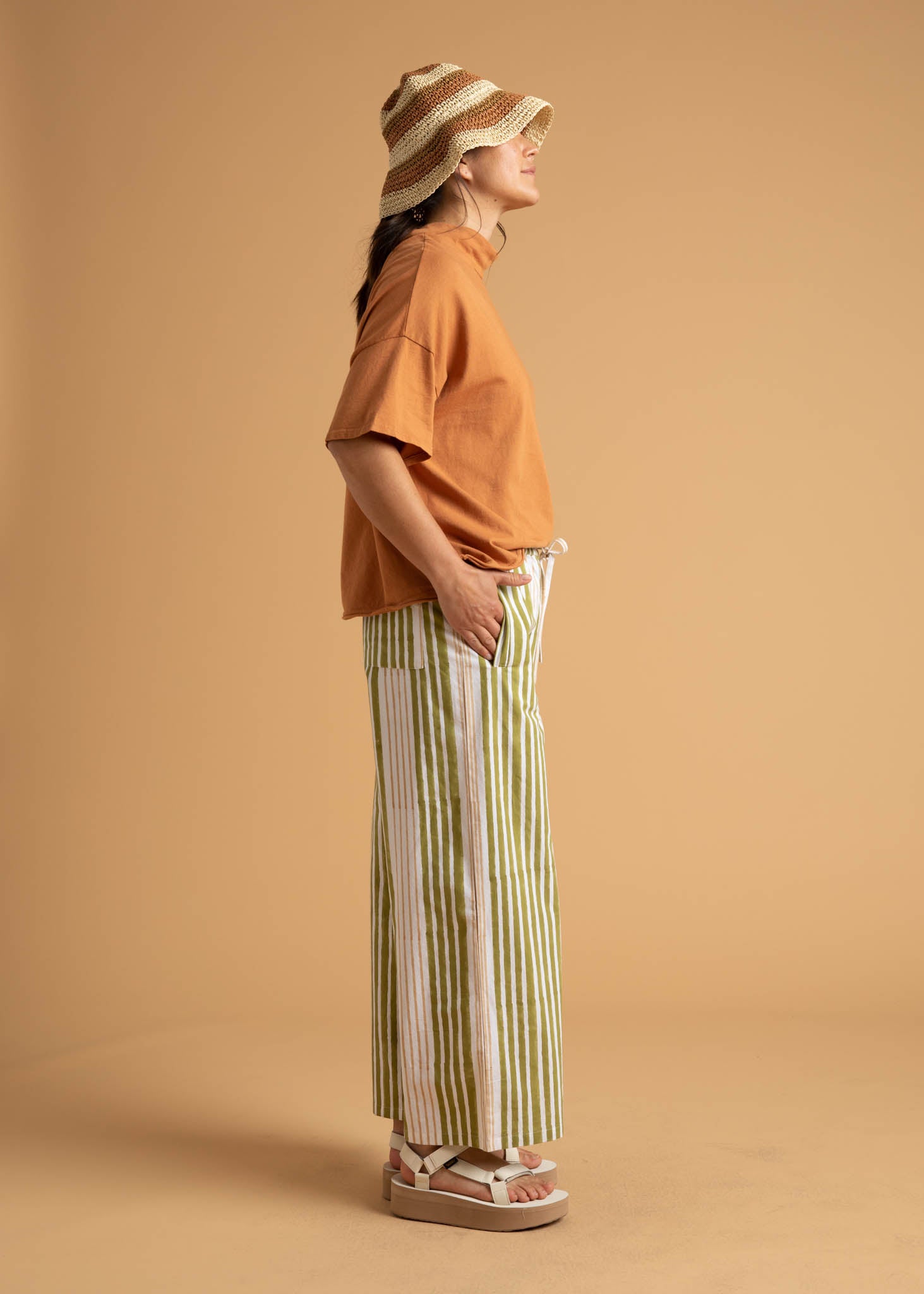 Shore Pant in Mixed Up Stripe Baked Clay & Olive Oil, showcasing a modern cropped design with a relaxed fit and elastic waist.