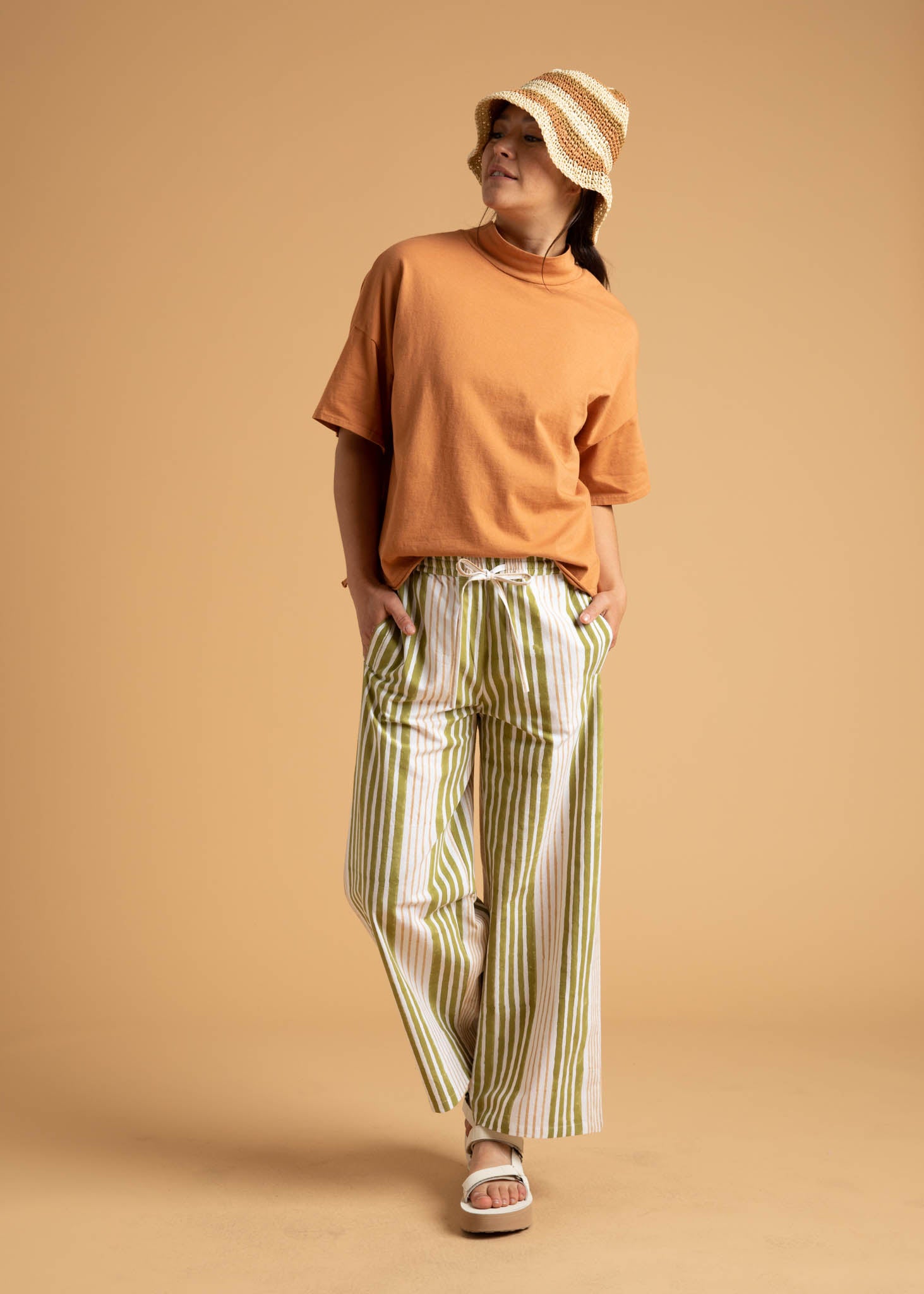 Shore Pant in Mixed Up Stripe Baked Clay & Olive Oil, showcasing a modern cropped design with a relaxed fit and elastic waist.