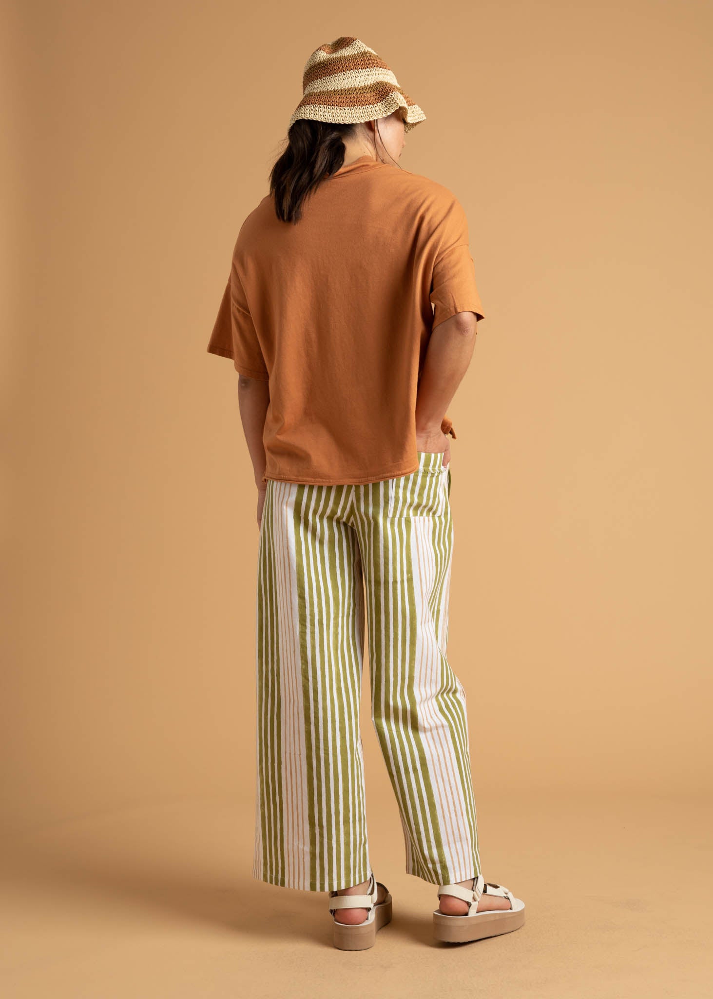 Shore Pant in Mixed Up Stripe Baked Clay & Olive Oil, showcasing a modern cropped design with a relaxed fit and elastic waist.