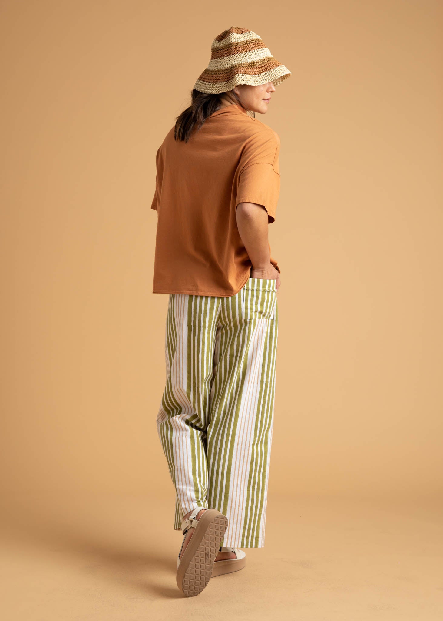Shore Pant in Mixed Up Stripe Baked Clay & Olive Oil, showcasing a modern cropped design with a relaxed fit and elastic waist.