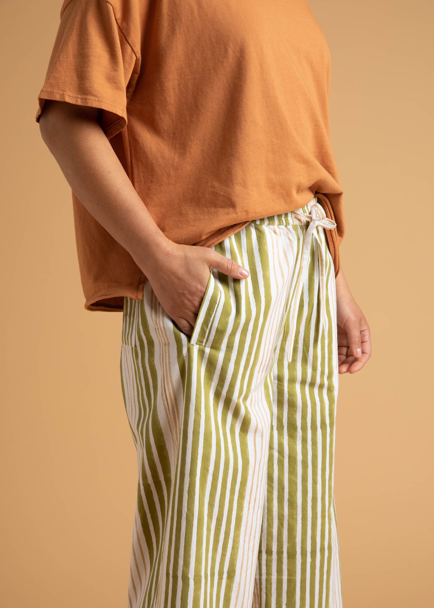 Shore Pant in Mixed Up Stripe Baked Clay & Olive Oil, showcasing a modern cropped design with a relaxed fit and elastic waist.