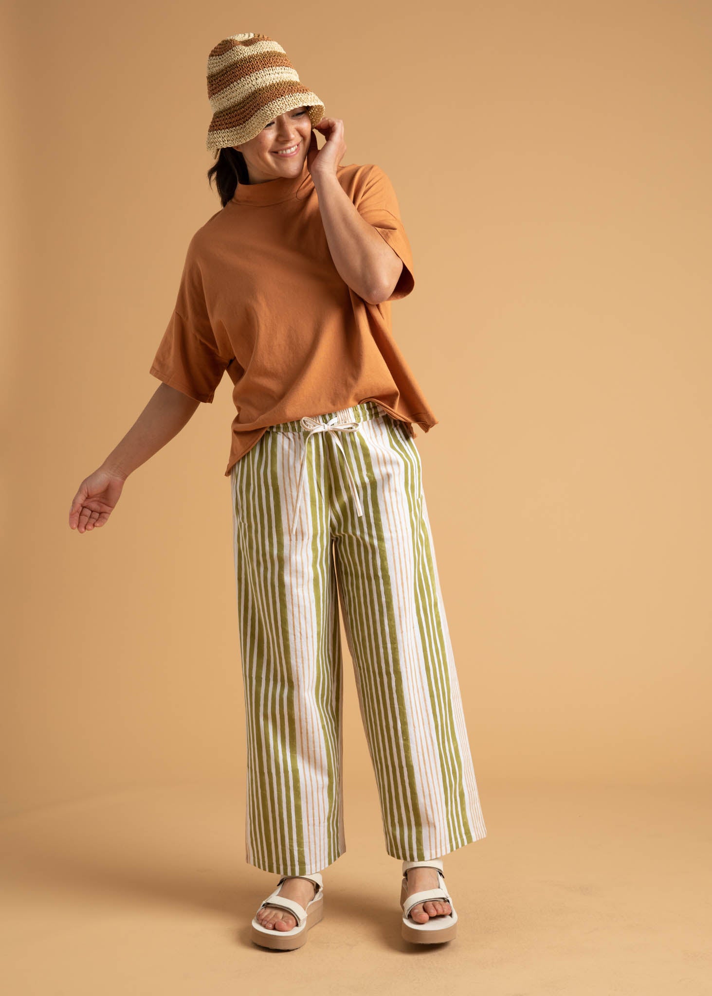 Shore Pant in Mixed Up Stripe Baked Clay & Olive Oil, showcasing a modern cropped design with a relaxed fit and elastic waist.