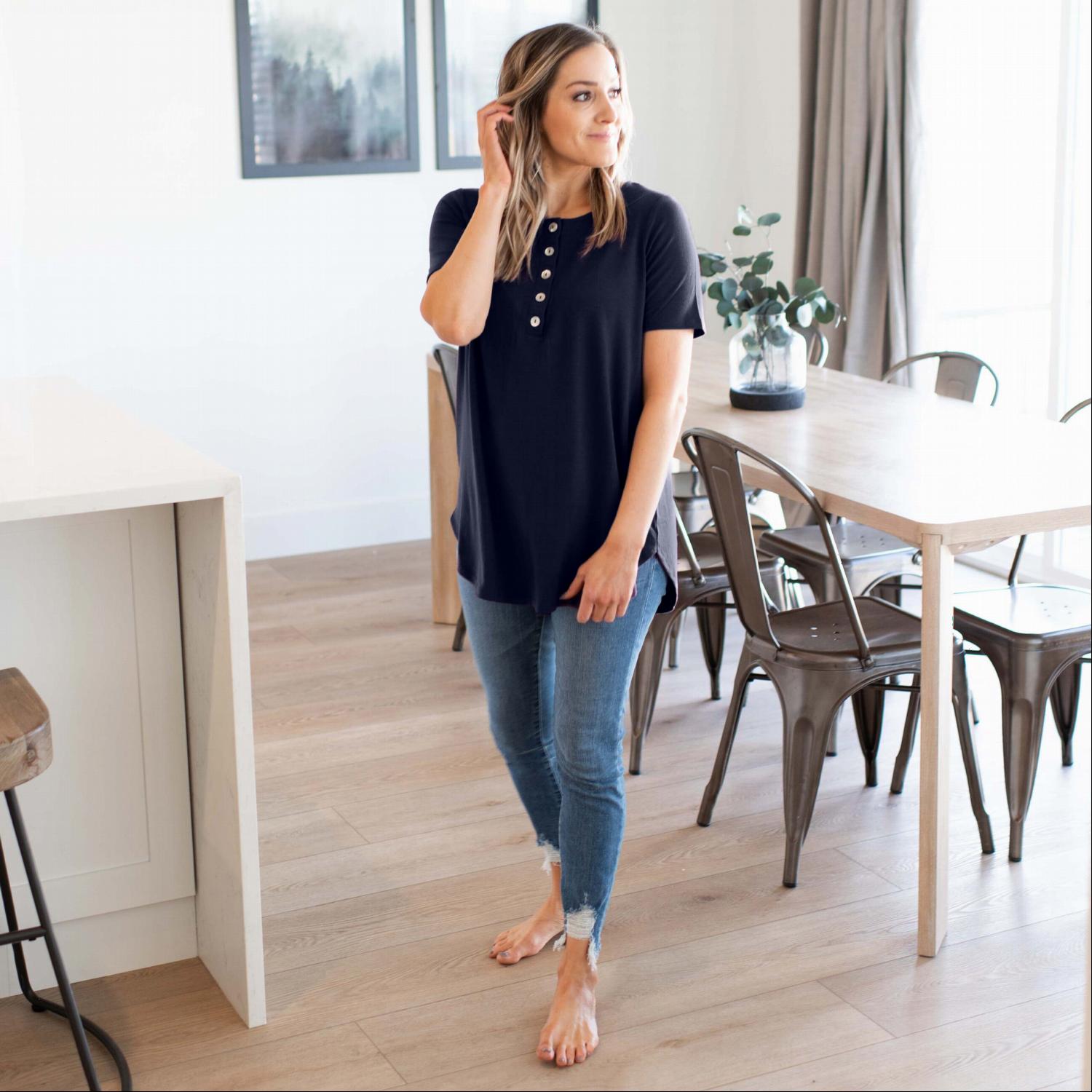 A stylish Short Sleeve Dolphin Hem Shell Button Top featuring button detailing and a loose fit, perfect for versatile outfits.