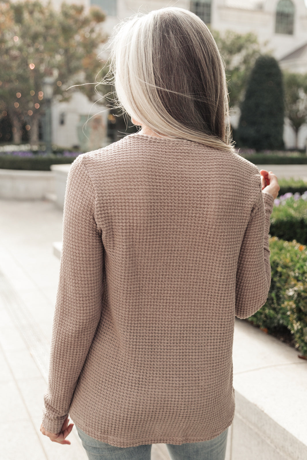 Side Of Art Top in Taupe featuring long sleeves and lace details cascading down the side, showcasing a stylish A-line silhouette.