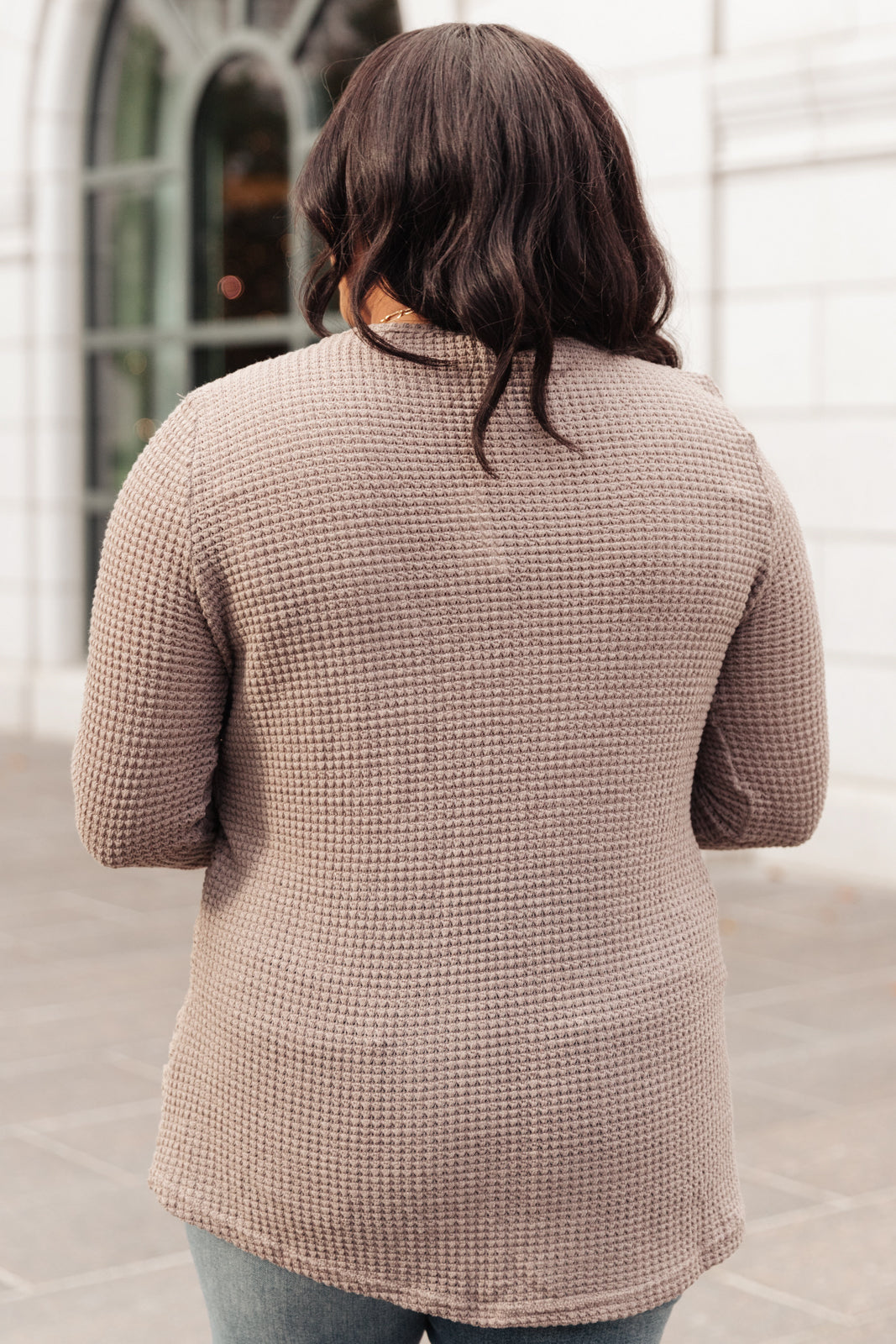 Side Of Art Top in Taupe featuring long sleeves and lace details cascading down the side, showcasing a stylish A-line silhouette.