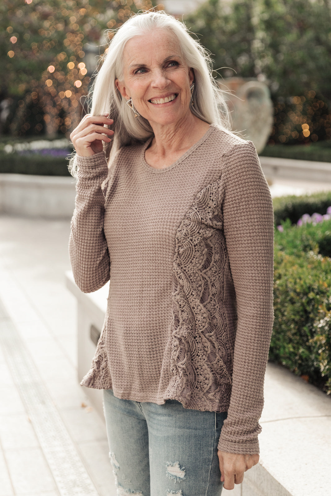 Side Of Art Top in Taupe featuring long sleeves and lace details cascading down the side, showcasing a stylish A-line silhouette.
