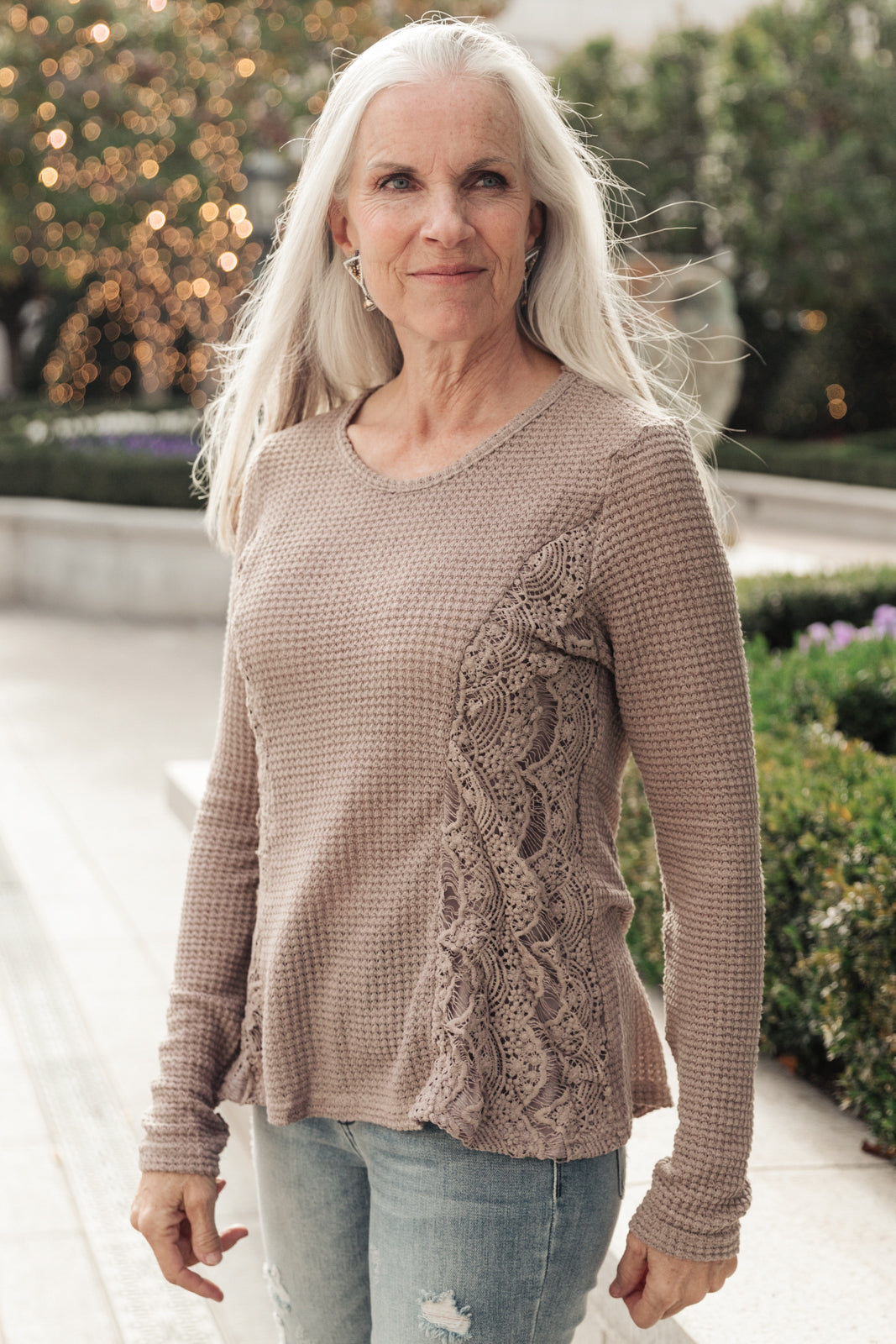 Side Of Art Top in Taupe featuring long sleeves and lace details cascading down the side, showcasing a stylish A-line silhouette.