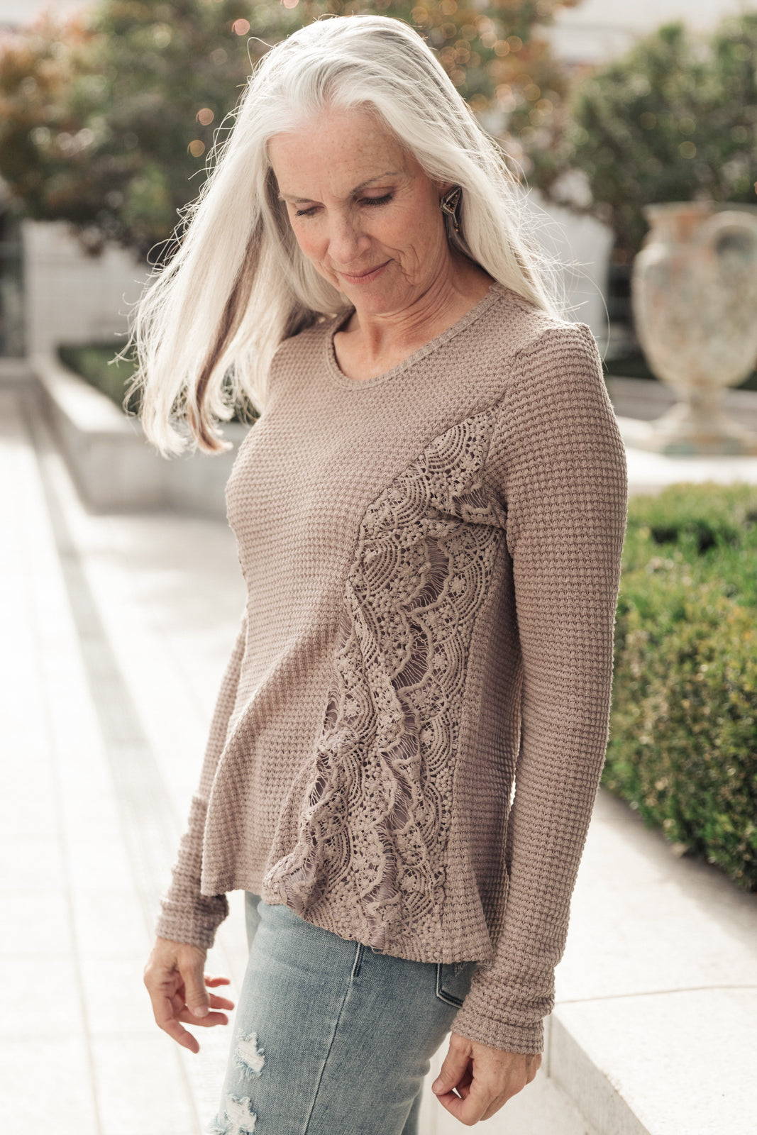 Side Of Art Top in Taupe featuring long sleeves and lace details cascading down the side, showcasing a stylish A-line silhouette.