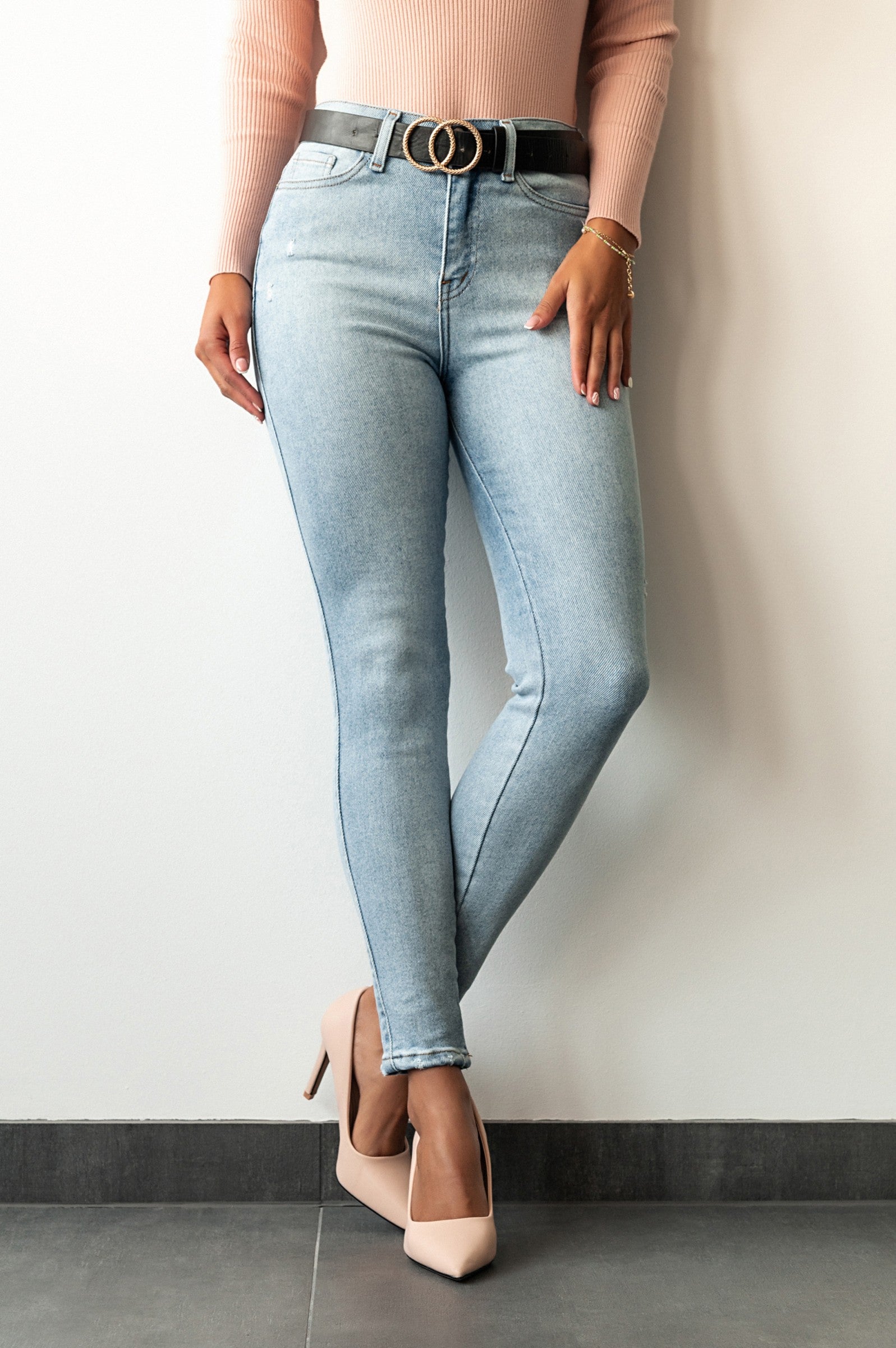 Light blue skinny stretch jeans with tapered leg, front and back pockets, zip and button closure, made from high-quality cotton.