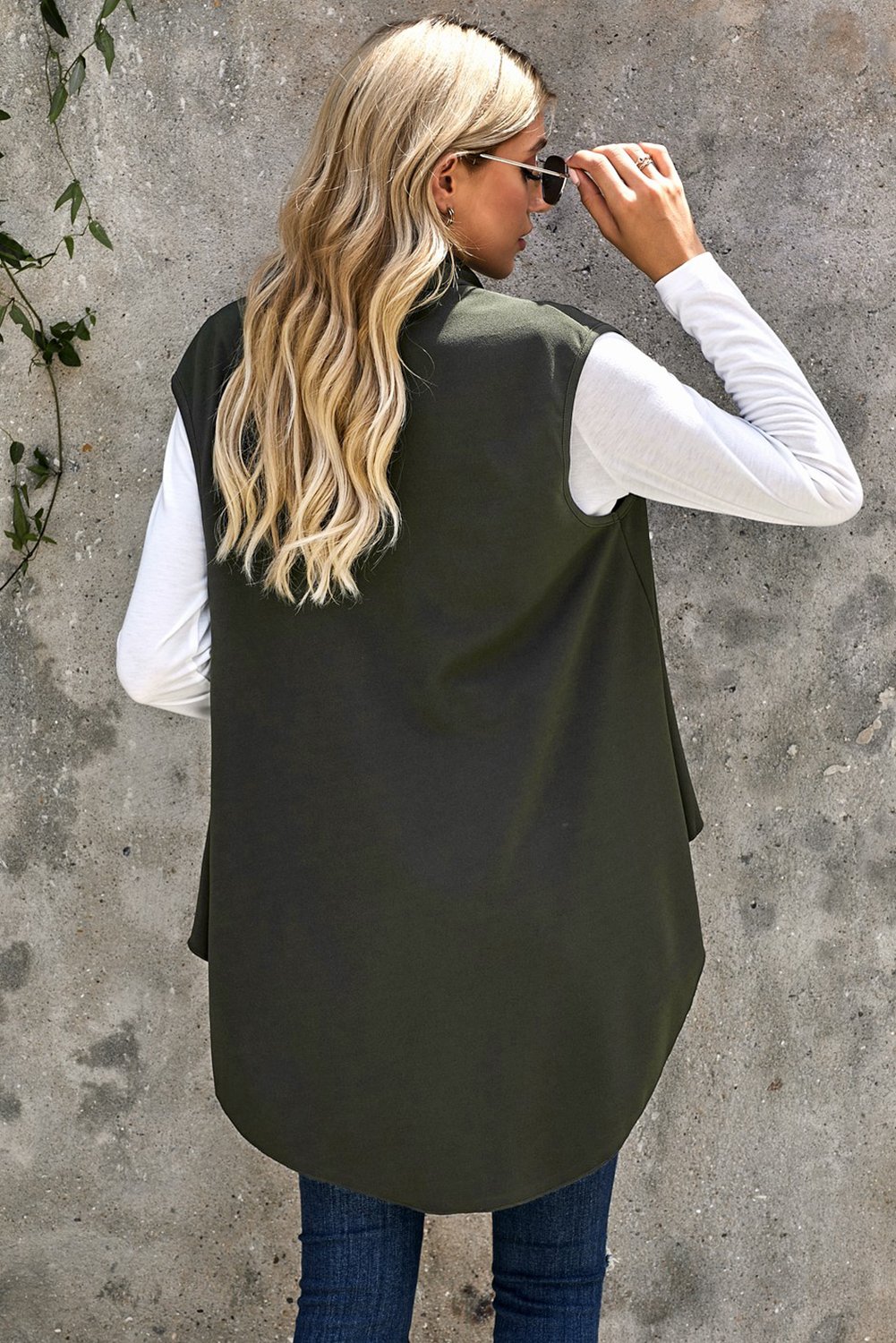 A stylish sleeveless cascade open front draped cardigan with a shawl neckline, showcasing a high-low hemline, perfect for layering.