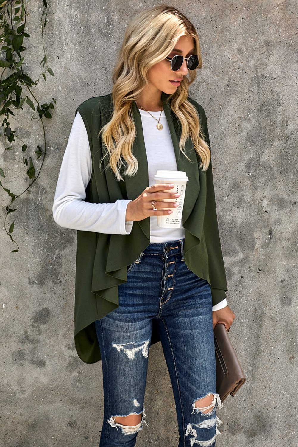 A stylish sleeveless cascade open front draped cardigan with a shawl neckline, showcasing a high-low hemline, perfect for layering.