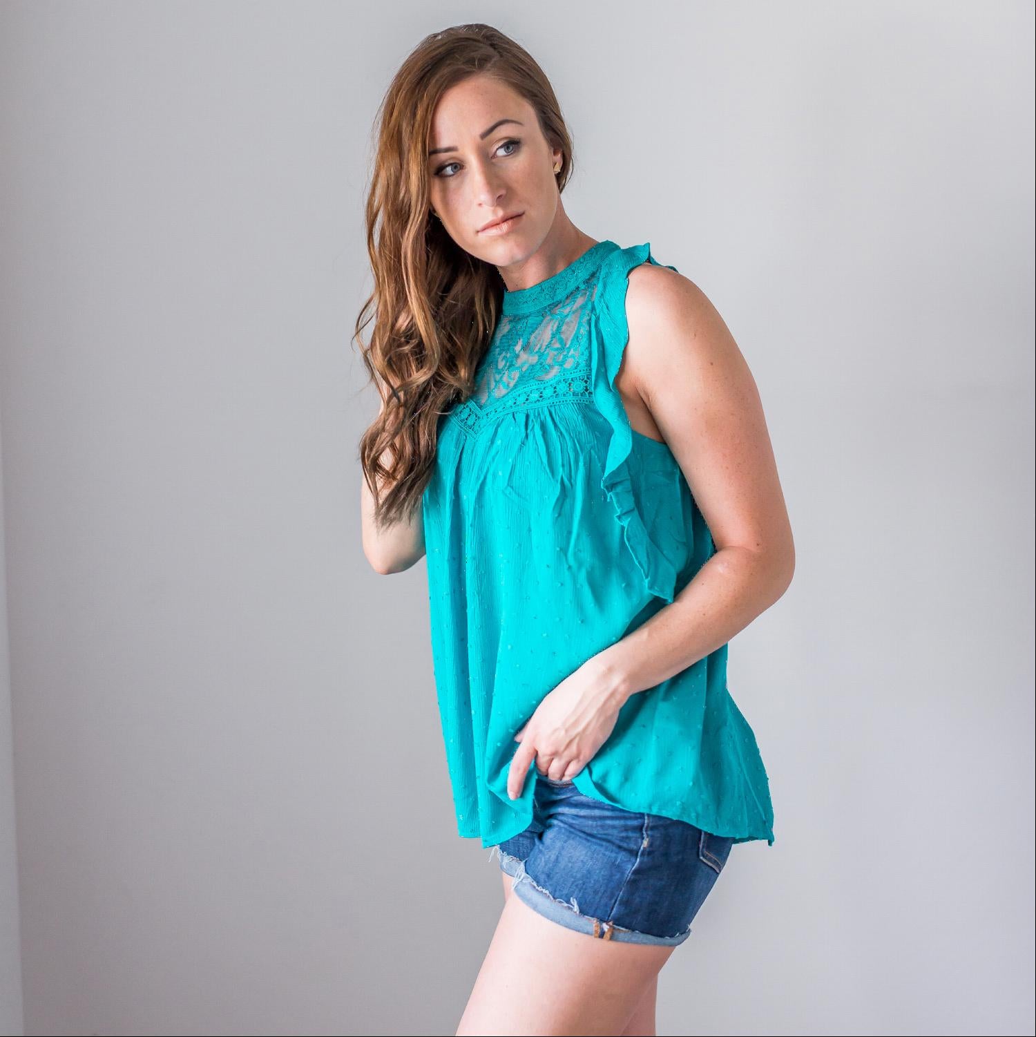 A stylish sleeveless polka dot mock neck top featuring a floral lace yoke and crochet trim, perfect for summer wear.